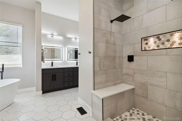 a spacious bathroom with a bathtub sink and mirror