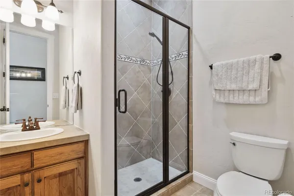 a bathroom with a shower sink mirror and toilet