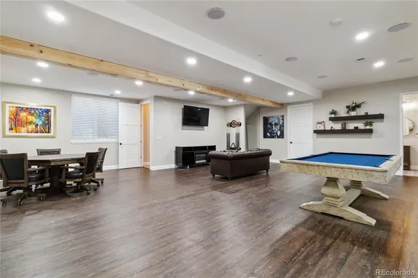 a living room with furniture and a dining table with wooden floor