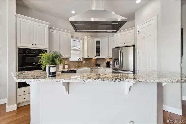a kitchen with stainless steel appliances kitchen island granite countertop a sink and cabinets