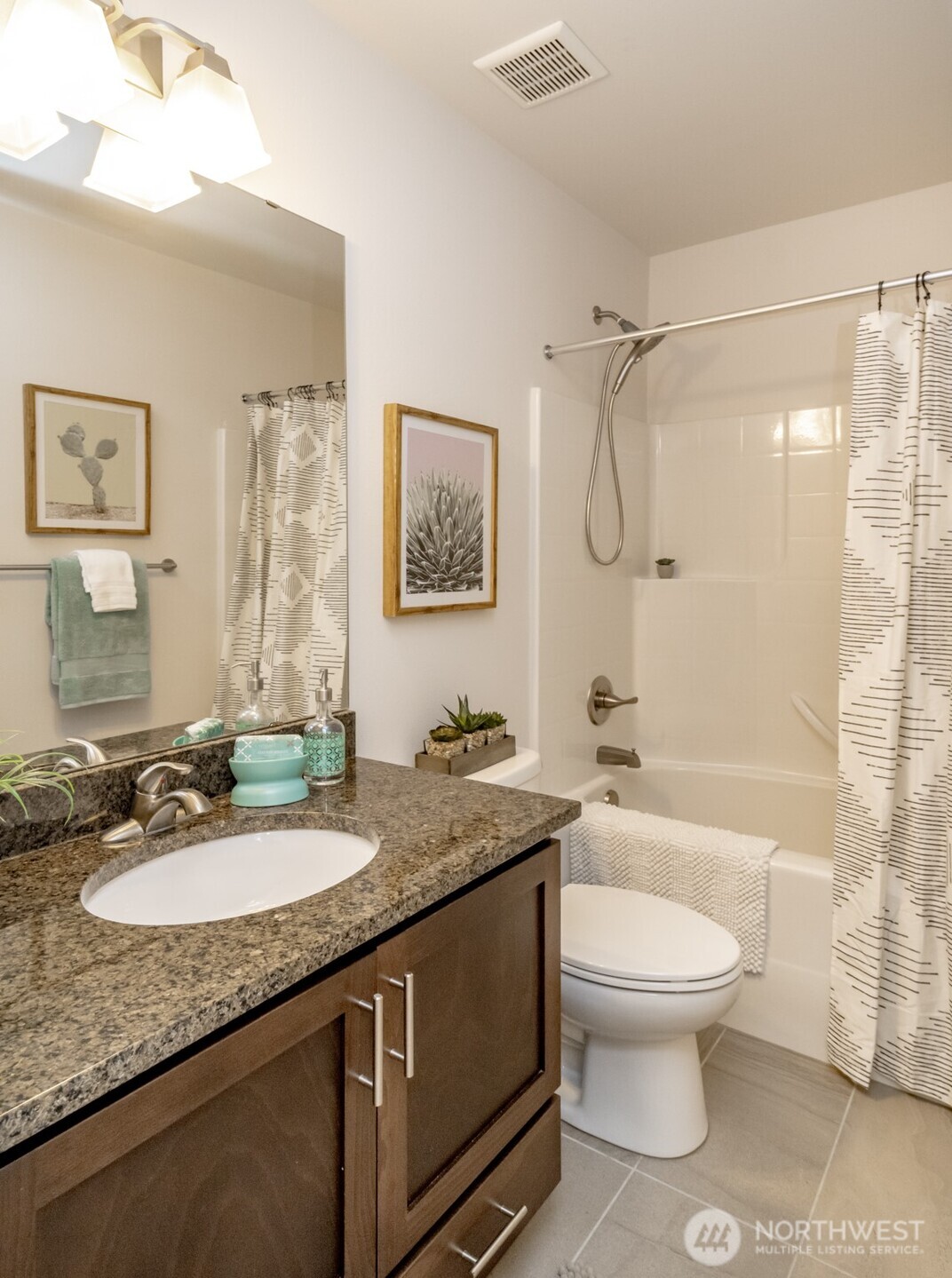 6830 31st Avenue Southwest Seattle, WA 98126 - Photo 21 of 28 a bathroom with a granite countertop sink a toilet a mirror a vanity a bath tub and shower