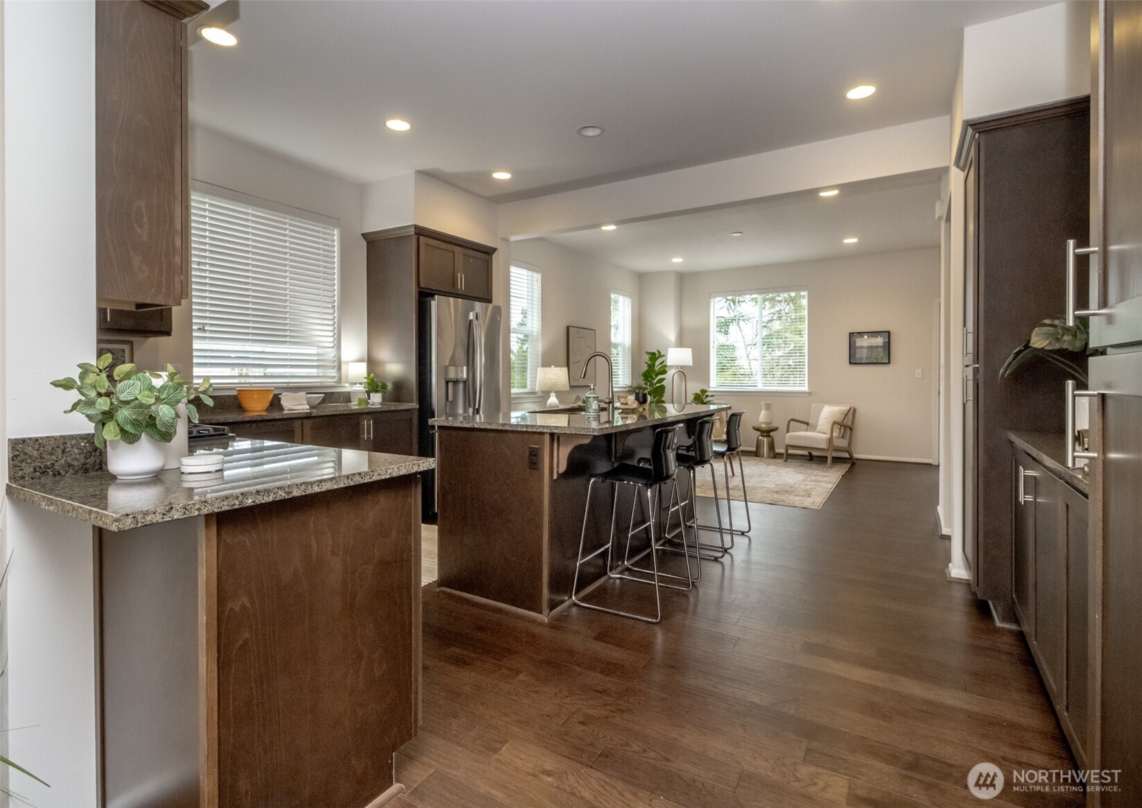 6830 31st Avenue Southwest Seattle, WA 98126 - Photo 8 of 28 a kitchen with stainless steel appliances granite countertop a refrigerator a sink dishwasher a stove and a dining table with wooden floor