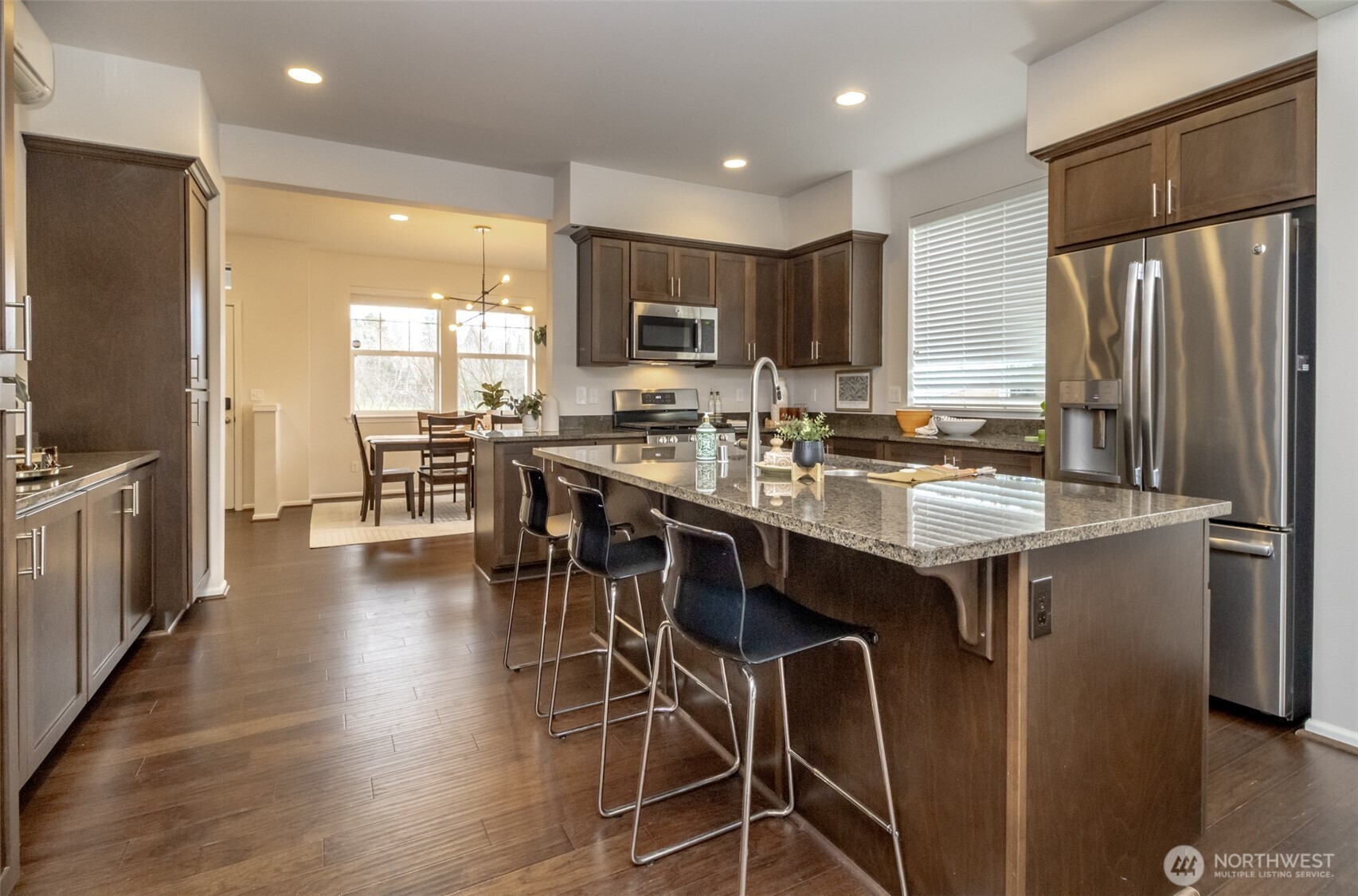 6830 31st Avenue Southwest Seattle, WA 98126 - Photo 9 of 28 a kitchen with stainless steel appliances a table chairs refrigerator and a sink