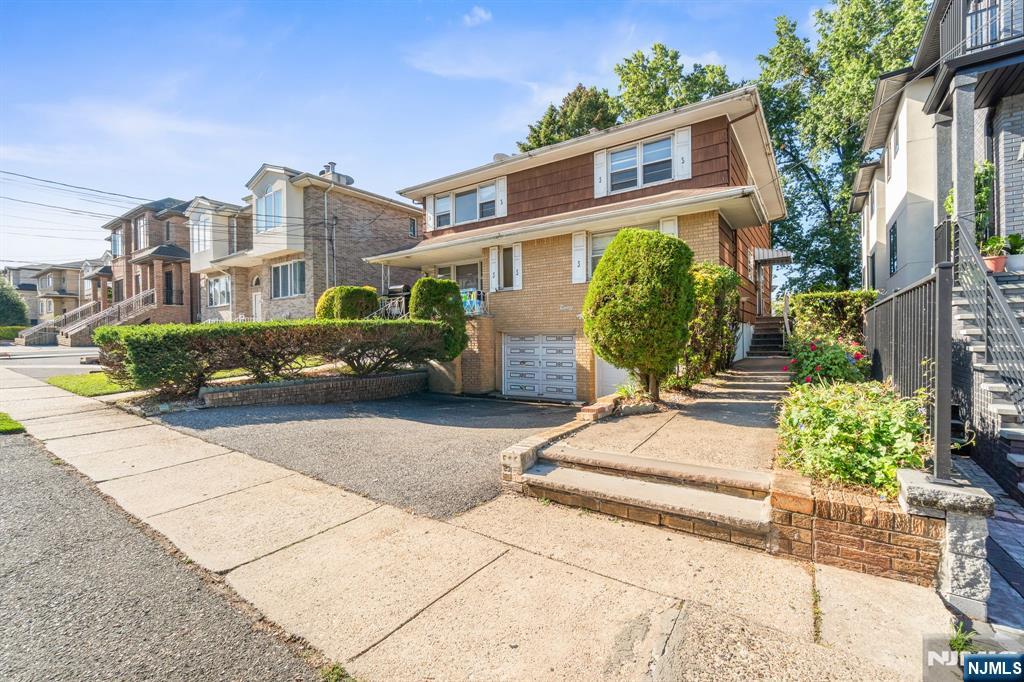 24 East Ruby Avenue, Unit 2 Palisades Park, NJ 07650 - Photo 19 of 19 a front view of a house with a yard and potted plants