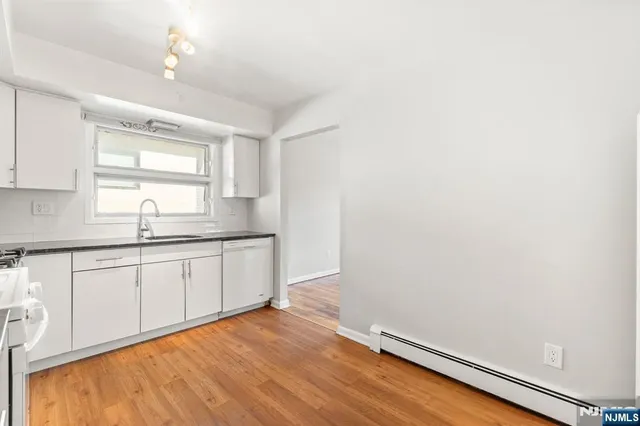 a kitchen with granite countertop white cabinets and white appliances