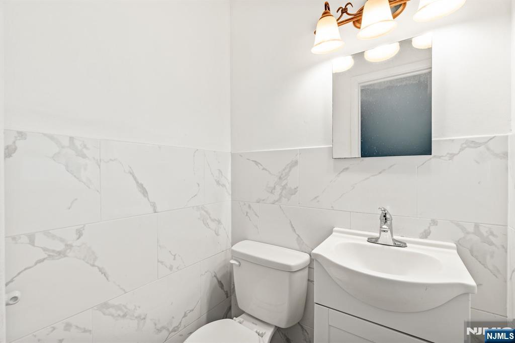 24 East Ruby Avenue, Unit 2 Palisades Park, NJ 07650 - Photo 4 of 19 a bathroom with a sink a toilet and mirror