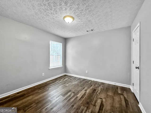 a view of room with window and hardwood floor
