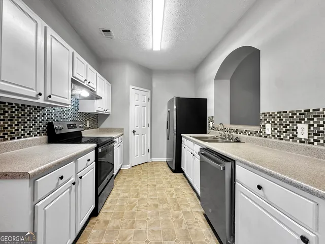 a kitchen with a sink stove and refrigerator