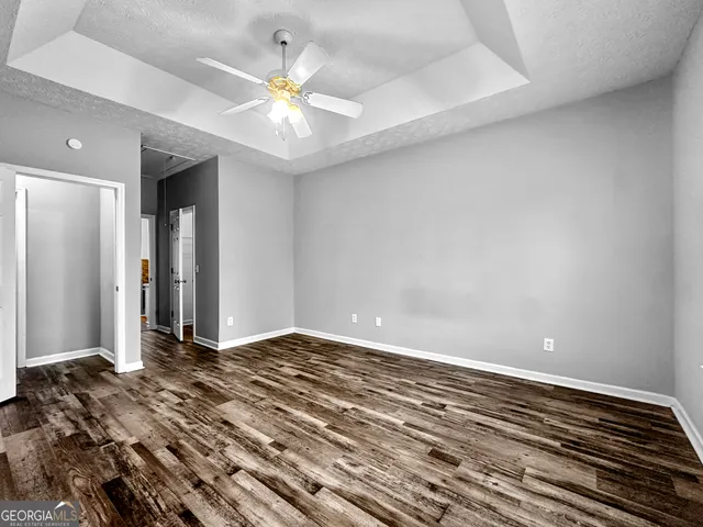 a view of a bedroom with wooden floor and a ceiling fan