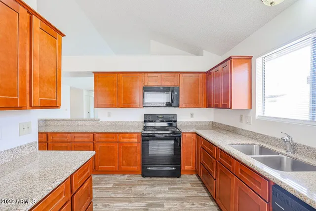 a kitchen with stainless steel appliances granite countertop a sink stove and refrigerator