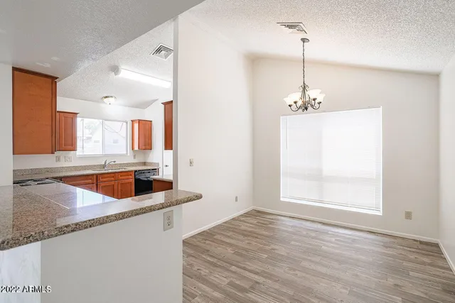 a kitchen with stainless steel appliances granite countertop a sink a counter space and a window
