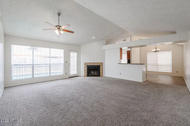 a view of an empty room with a fireplace and a window