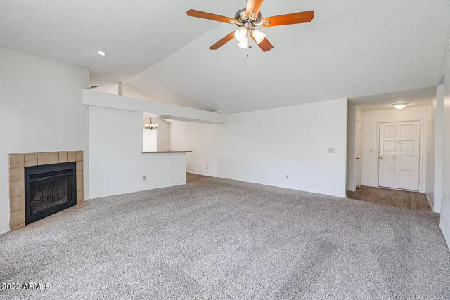 an empty room with windows and fireplace