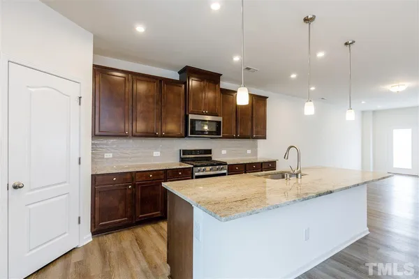 a kitchen with a sink cabinets and wooden floor