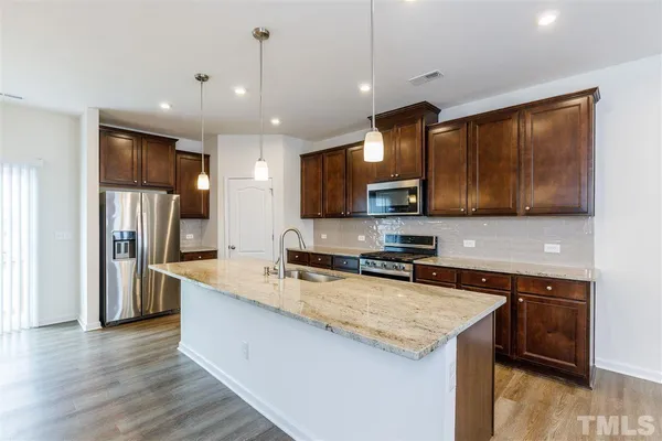a kitchen with stainless steel appliances granite countertop a sink stove and refrigerator