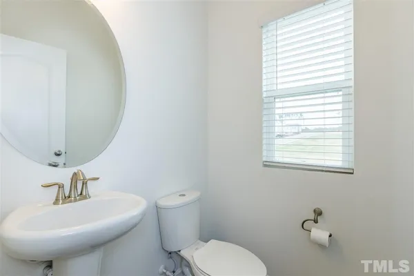 a bathroom with a toilet a sink and a mirror