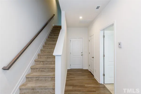 a view of a hallway with wooden floor and entryway