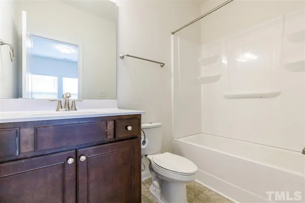 a bathroom with a sink a toilet a mirror and shower