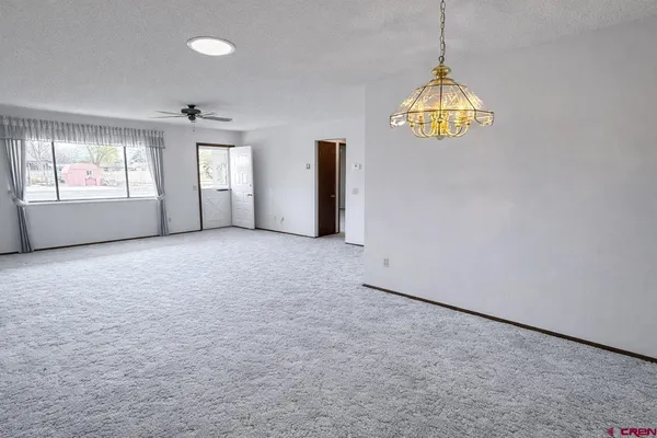 an empty room with a windows and chandelier