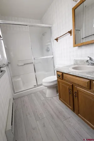 a bathroom with a sink a toilet and shower
