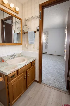 a bathroom with a granite countertop sink a mirror and a shower