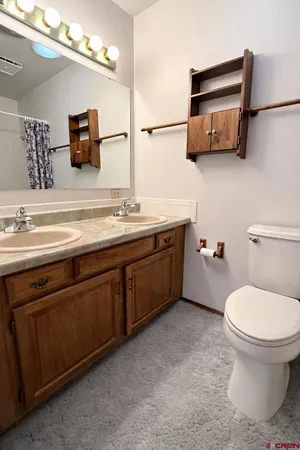 a bathroom with a toilet sink and mirror
