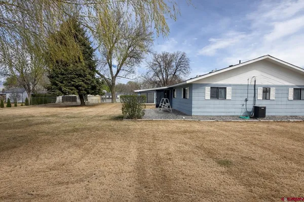 a front view of house with yard and trees