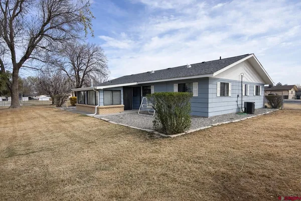 a view of a house with a yard and potted plants
