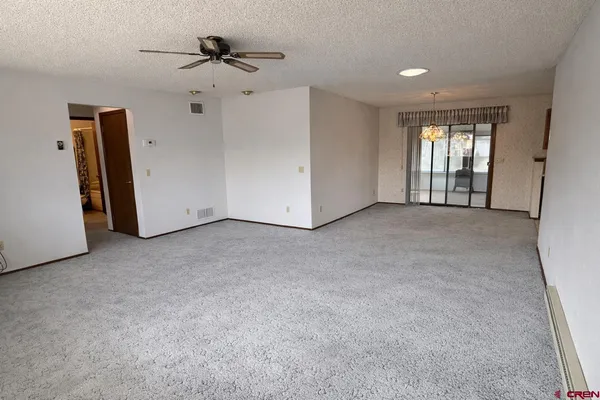 a view of a livingroom with a ceiling fan and window