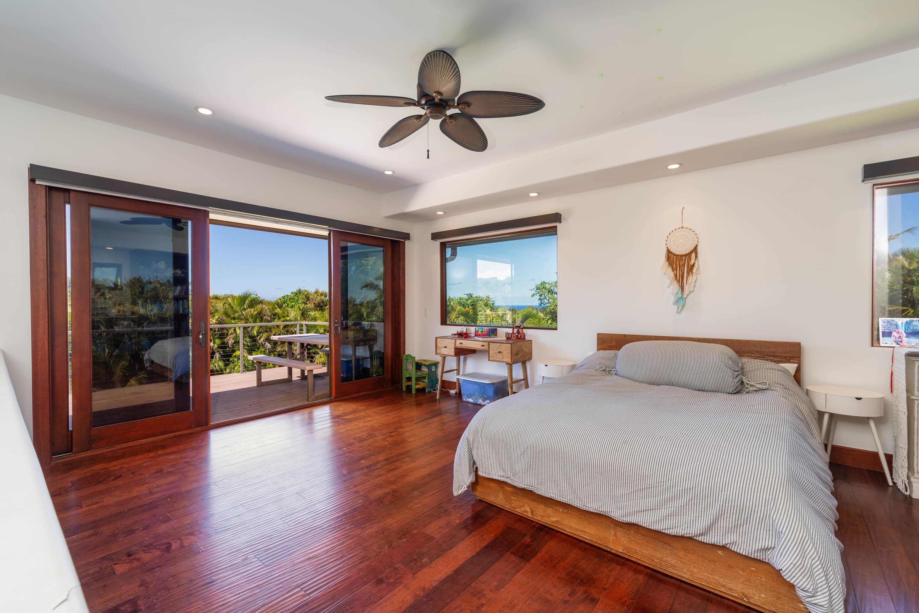 166 Apuwai Street Haiku, HI 96708 - Photo 15 of 30 a bedroom with a bed and a wooden floor