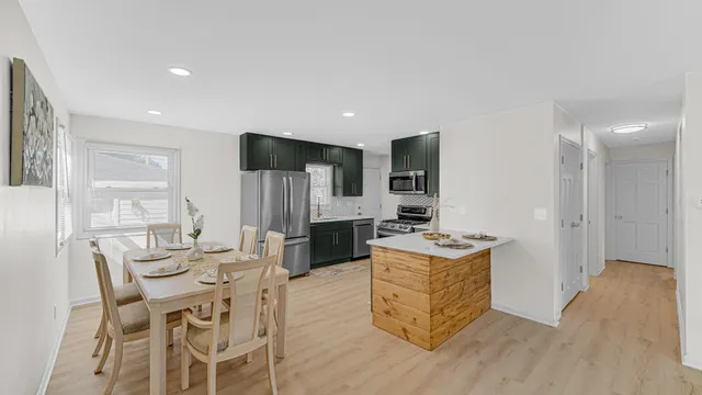 a living room with stainless steel appliances kitchen island granite countertop furniture and wooden floor