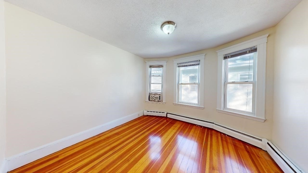 17 Gorham Road, Unit 2 Medford, MA 02155 - Photo 18 of 37 an empty room with wooden floor and windows
