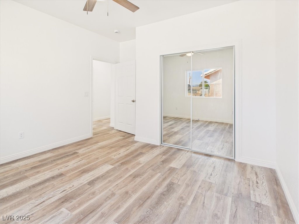 931 Lone Pine Road Pahrump, NV 89048 - Photo 12 of 48 Unfurnished bedroom featuring light wood-type flooring, a ceiling fan, and a closet