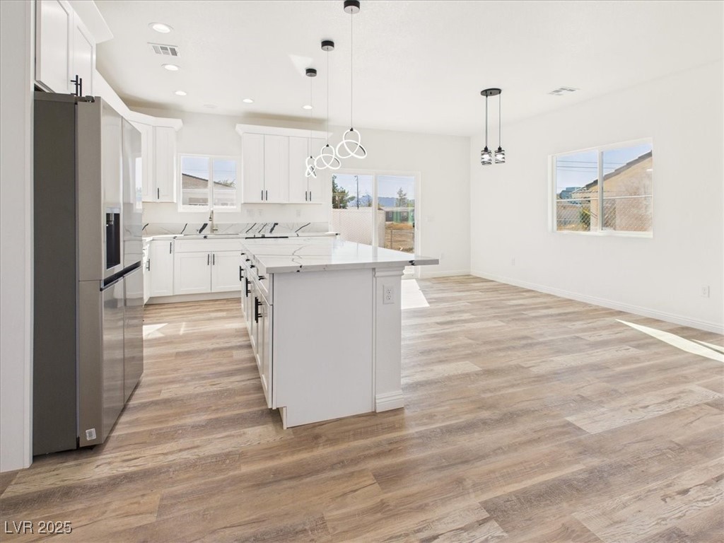 931 Lone Pine Road Pahrump, NV 89048 - Photo 3 of 48 Kitchen featuring stainless steel fridge with ice dispenser, decorative light fixtures, a kitchen island, light wood finished floors, and recessed lighting