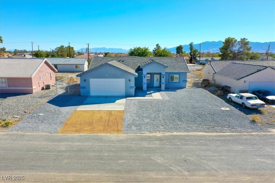 931 Lone Pine Road Pahrump, NV 89048 - Photo 38 of 48 Single story home with driveway, a residential view, stucco siding, a tile roof, and a mountain view
