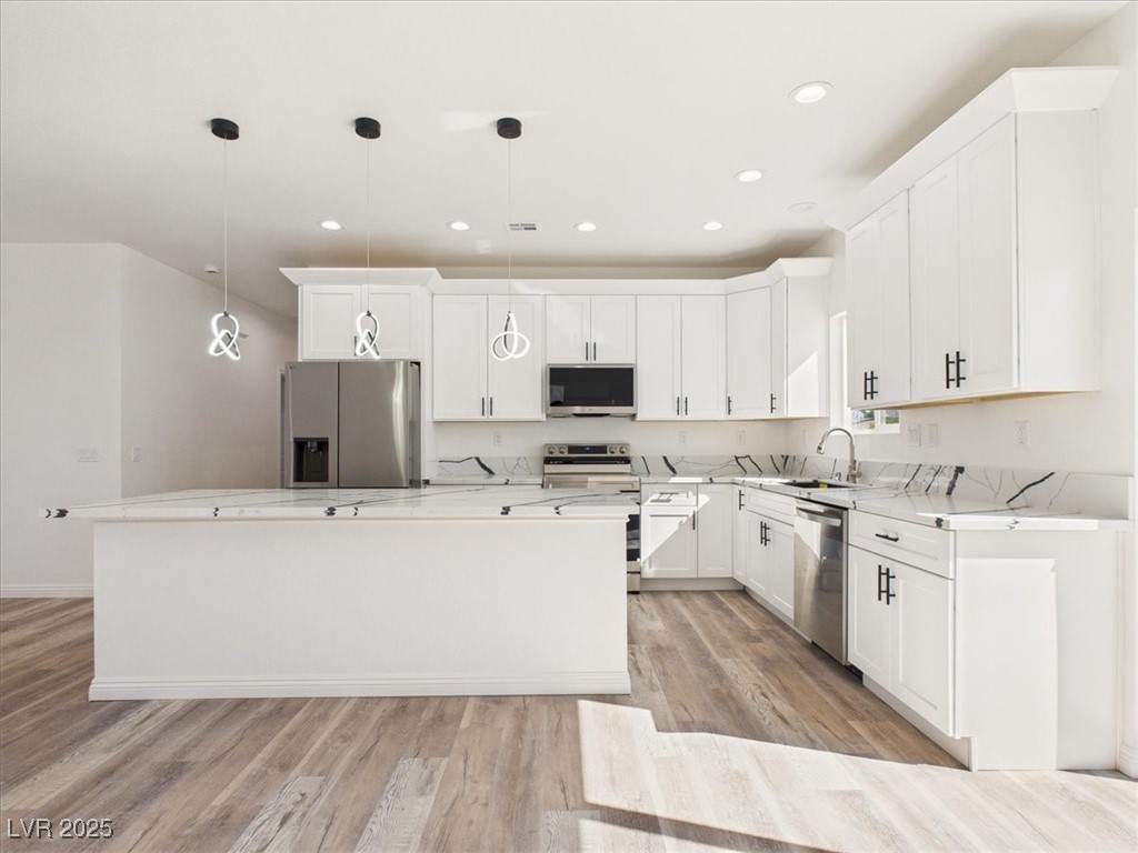 931 Lone Pine Road Pahrump, NV 89048 - Photo 5 of 48 Kitchen featuring pendant lighting, appliances with stainless steel finishes, a center island, light wood-type flooring, and white cabinetry