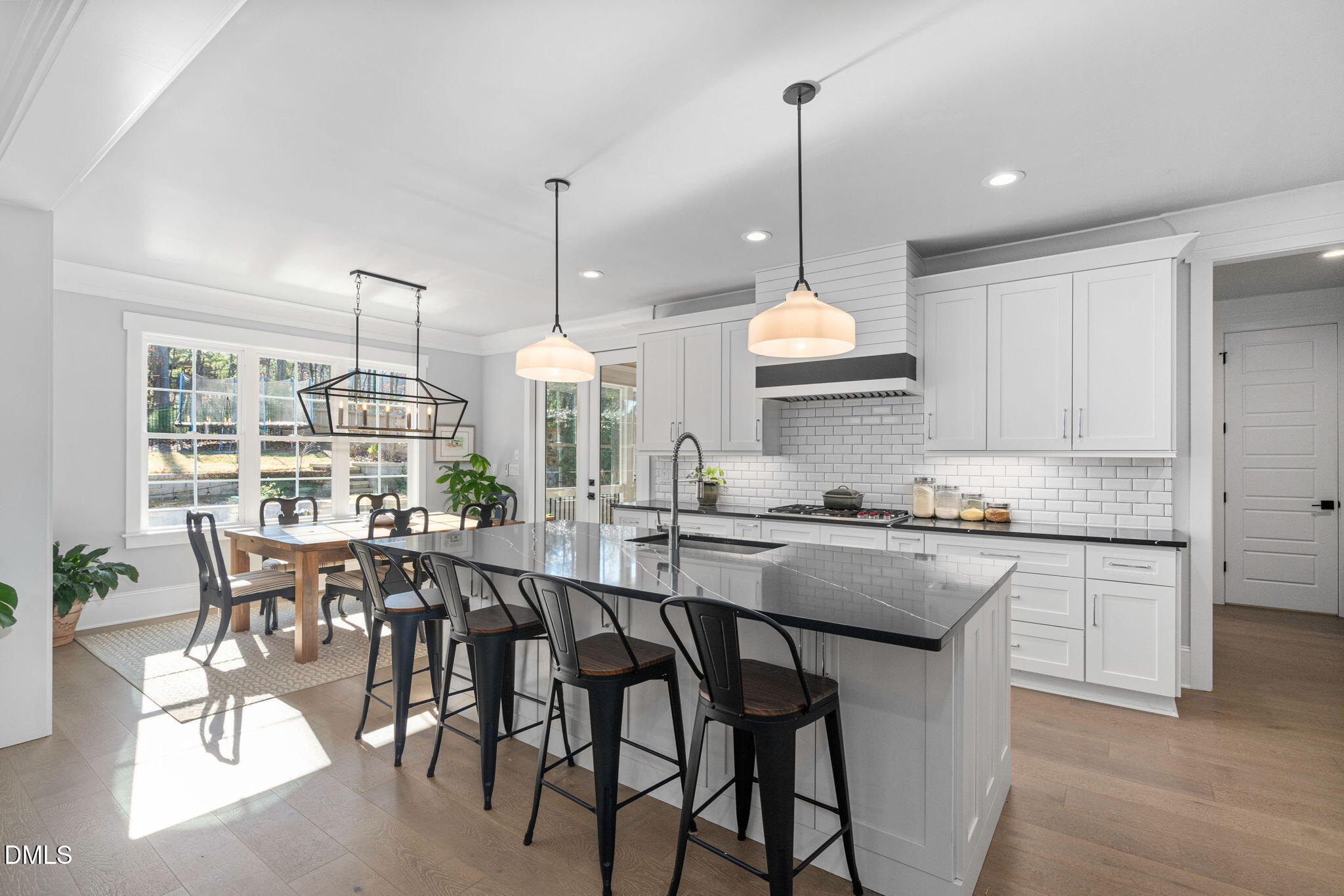 3417 Edgemont Drive Raleigh, NC 27612 - Photo 11 of 70 a kitchen with stainless steel appliances granite countertop a stove a refrigerator a kitchen island a dining table and chairs with wooden floor
