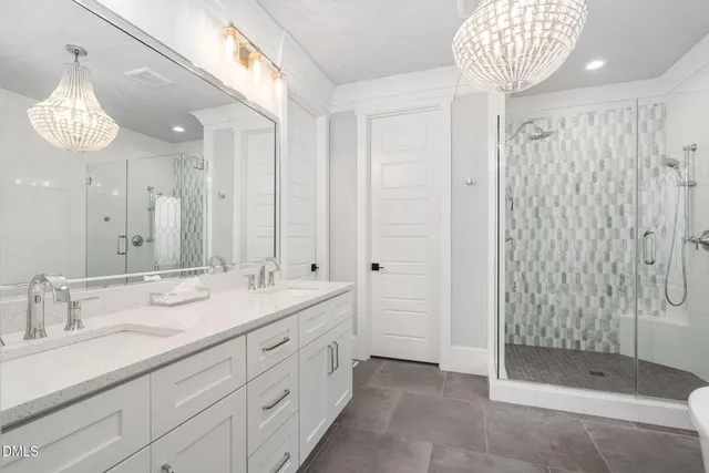 a en suite bathroom with a double vanity sink and a mirror