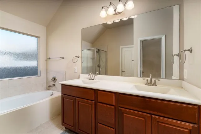 a bathroom with a sink double vanity granite tub and a mirror