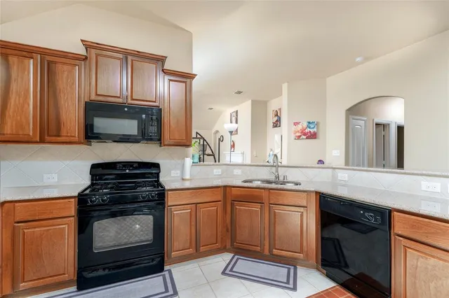 a kitchen with granite countertop a stove sink and cabinets