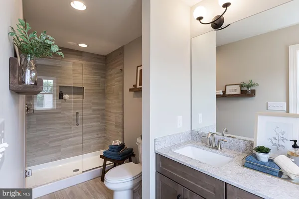 a bathroom with a sink a toilet and shower