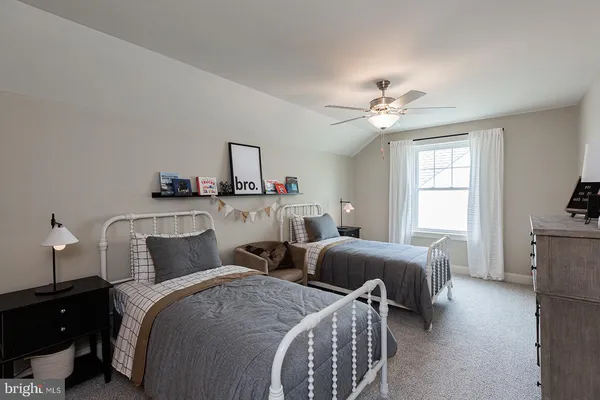 a bedroom with two beds and a chandelier