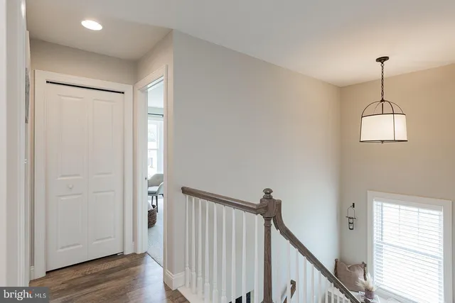 a view of a hallway with wooden floor and stairs