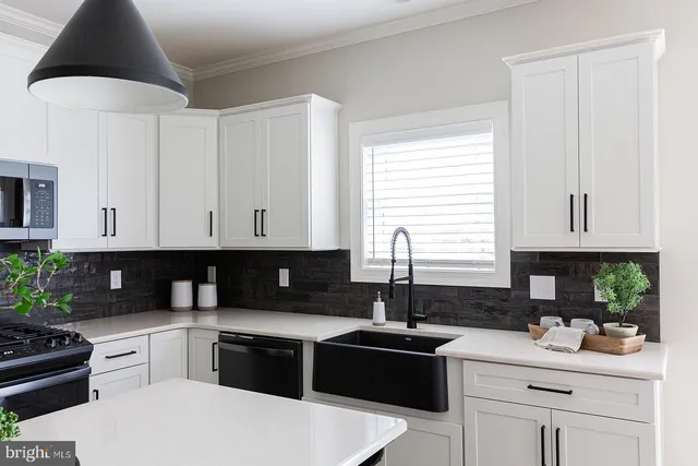 a kitchen with a white cabinets and window