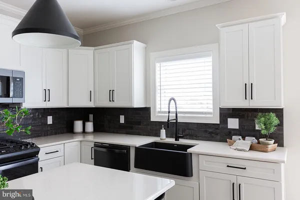 a kitchen with a white cabinets and window