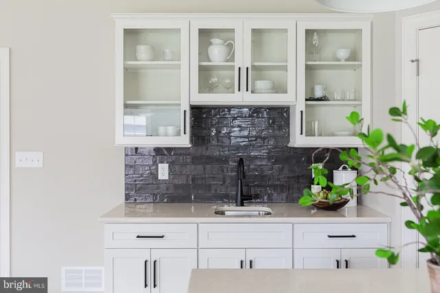 a kitchen with a white cabinets and a potted plant