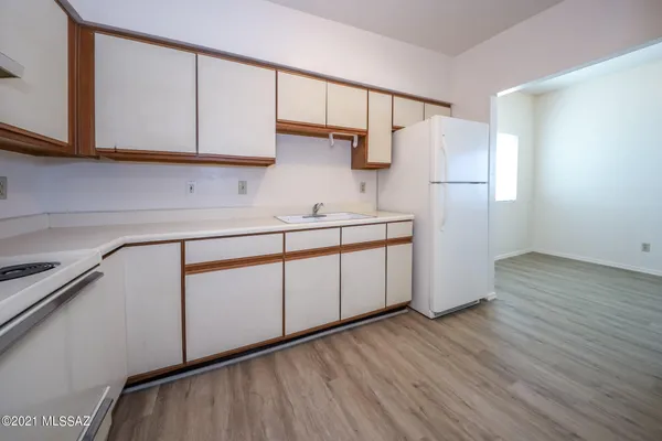 a kitchen with a sink a refrigerator and cabinets