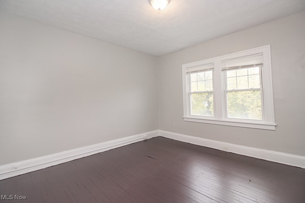 3085 Somerton Road Cleveland, OH 44118 - Photo 11 of 16 Spare room featuring dark wood-style floors and baseboards