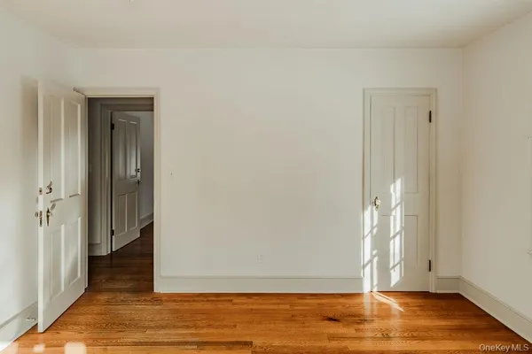 a view of empty room with wooden floor