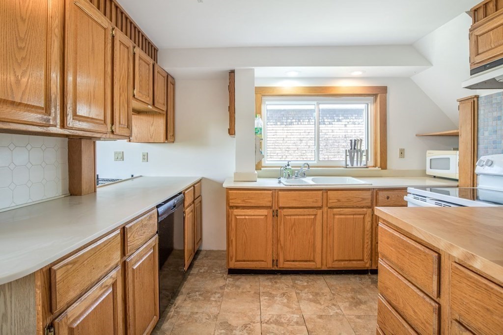 23 Cliff Road Gloucester, MA 01930 - Photo 15 of 37 a kitchen with stainless steel appliances granite countertop a sink and a stove
